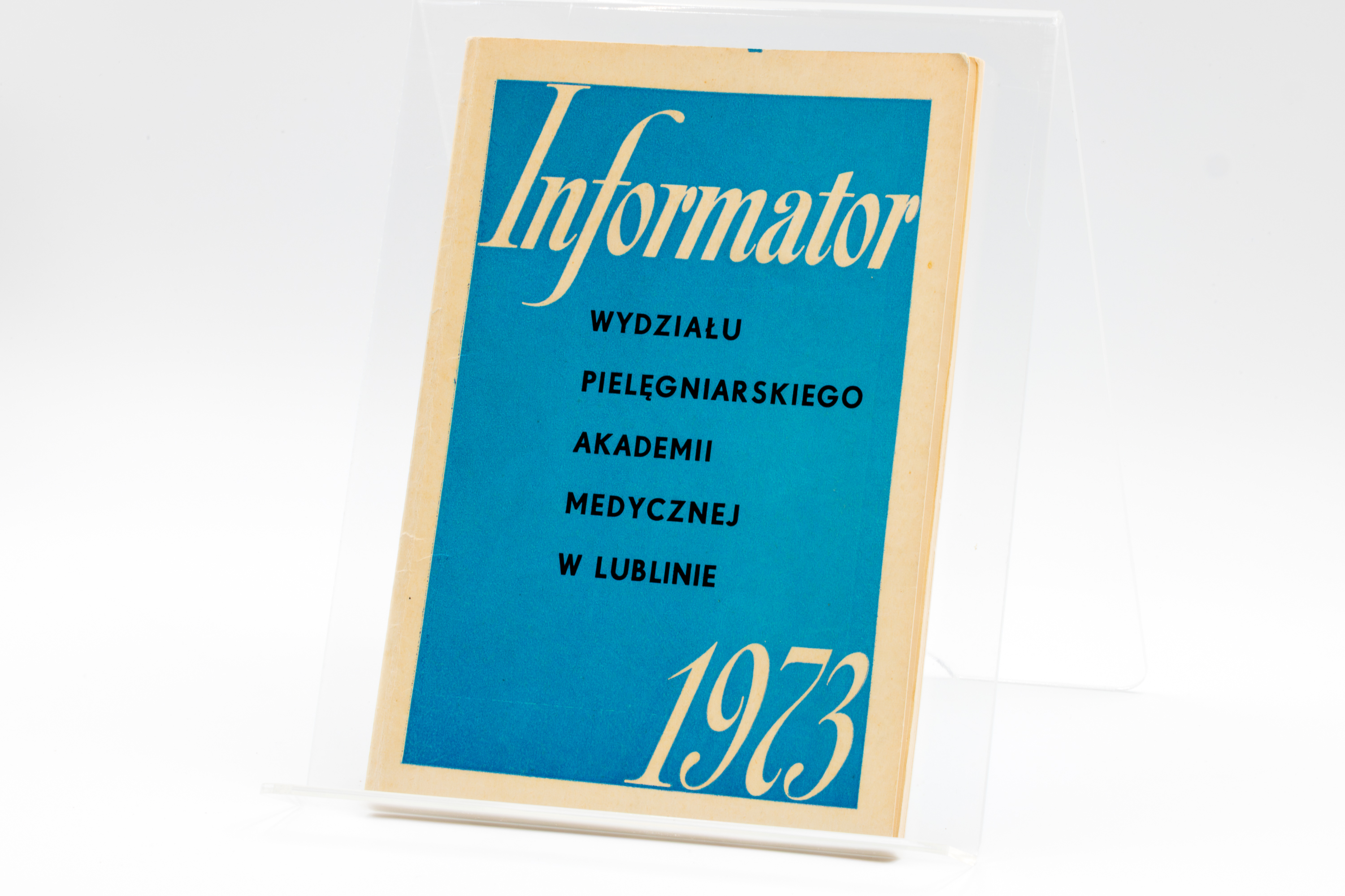 Zdjęcie przedstawia okładkę informatora Wydziału Pielęgniarskiego Akademii Medycznej w Lublinie. Jest to broszura w kolorze niebieskim, na której widnieją napisy w kolorze kremowym. Duży, kursywny napis u góry to „Informator”. Poniżej, w mniejszym rozmiarze, znajdują się kolejne wiersze tekstu: WYDZIAŁU PIELĘGNIARSKIEGO AKADEMII MEDYCZNEJ W LUBLINIE. W prawym dolnym rogu okładki widoczna jest duża liczba „1973”.